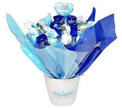 עציץ לבן בקישוט של נייר כחול/ תכלת ושוקולדים בעטיפות בצבעים תכלת, כחול ולבן.
